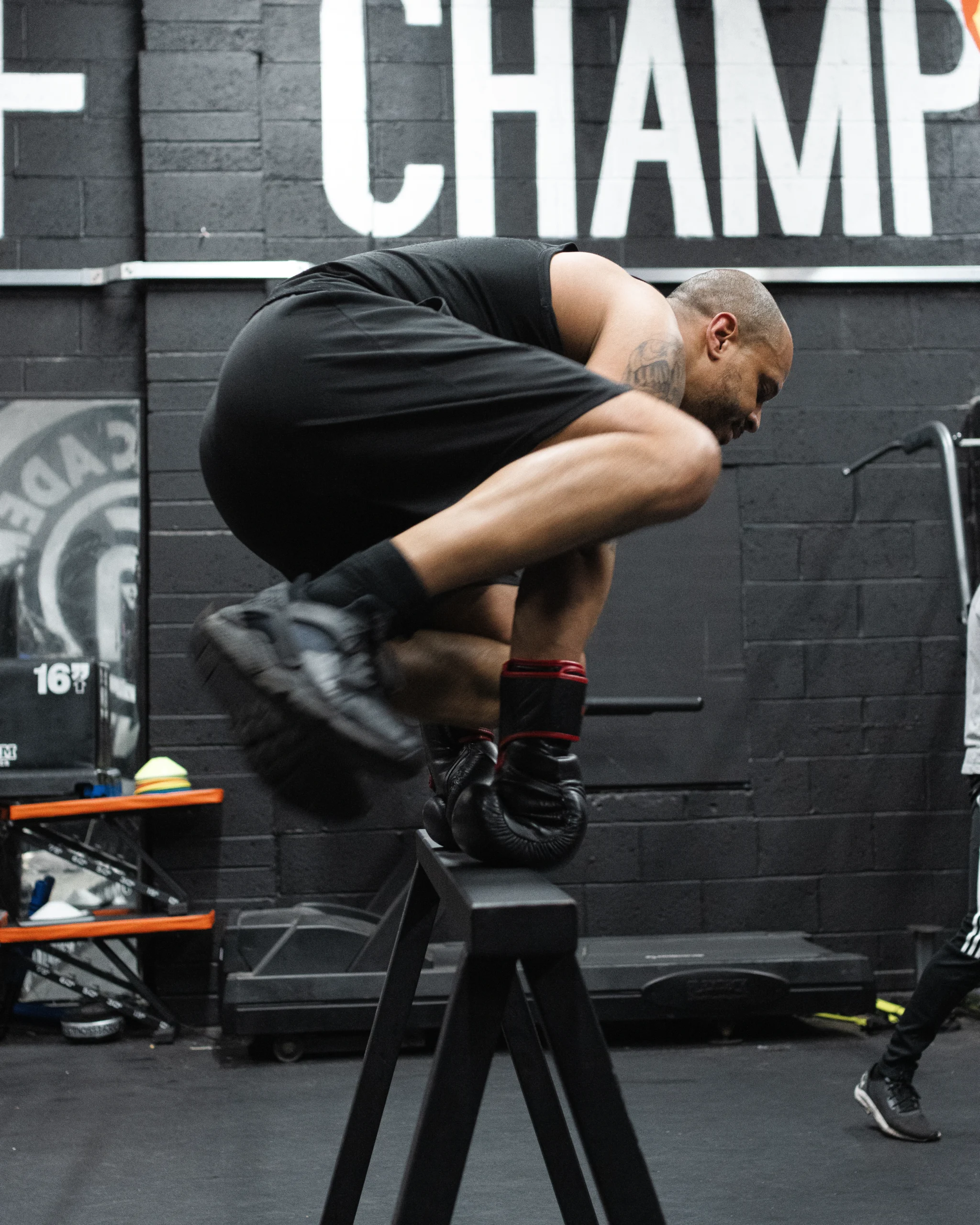 A man jumping over a bar in one of our boxing fitness sessions