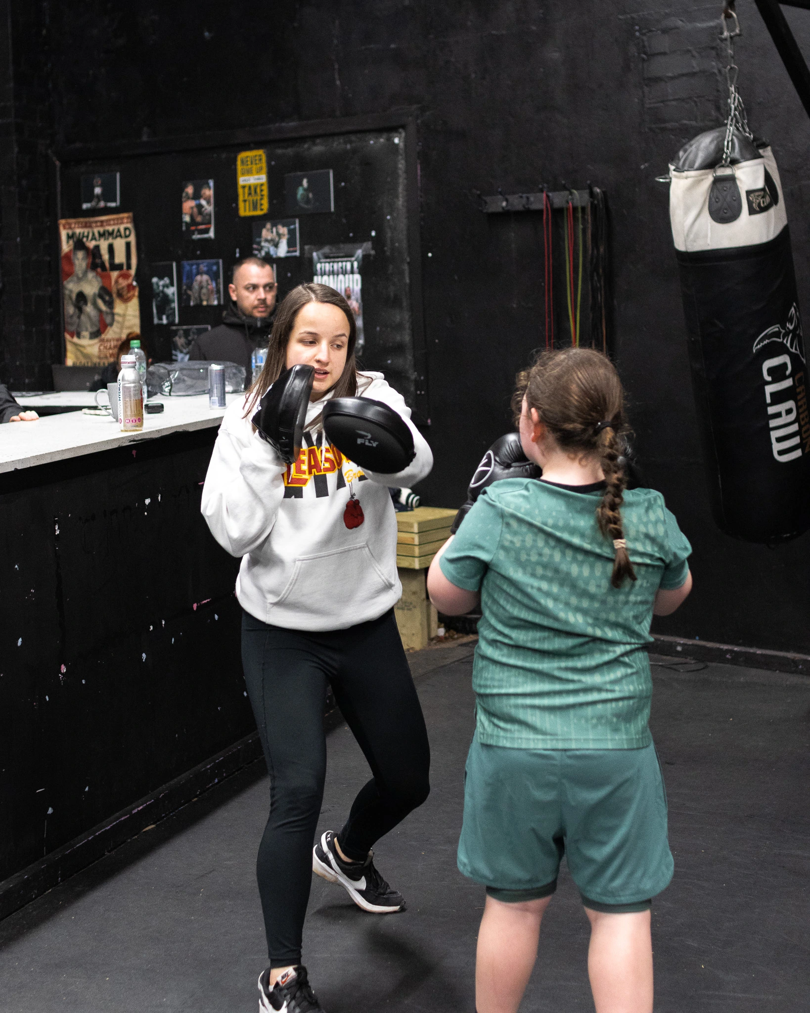 picture of a boxing coach teaching a young fight academy student in our children's boxing class